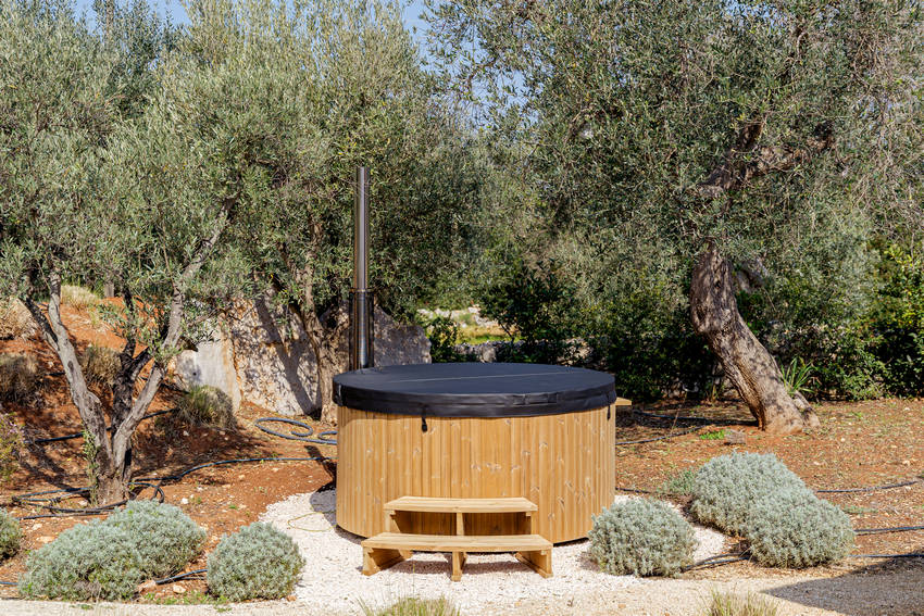 Trullo Petrarolo outdoor hot tub in garden with olive trees