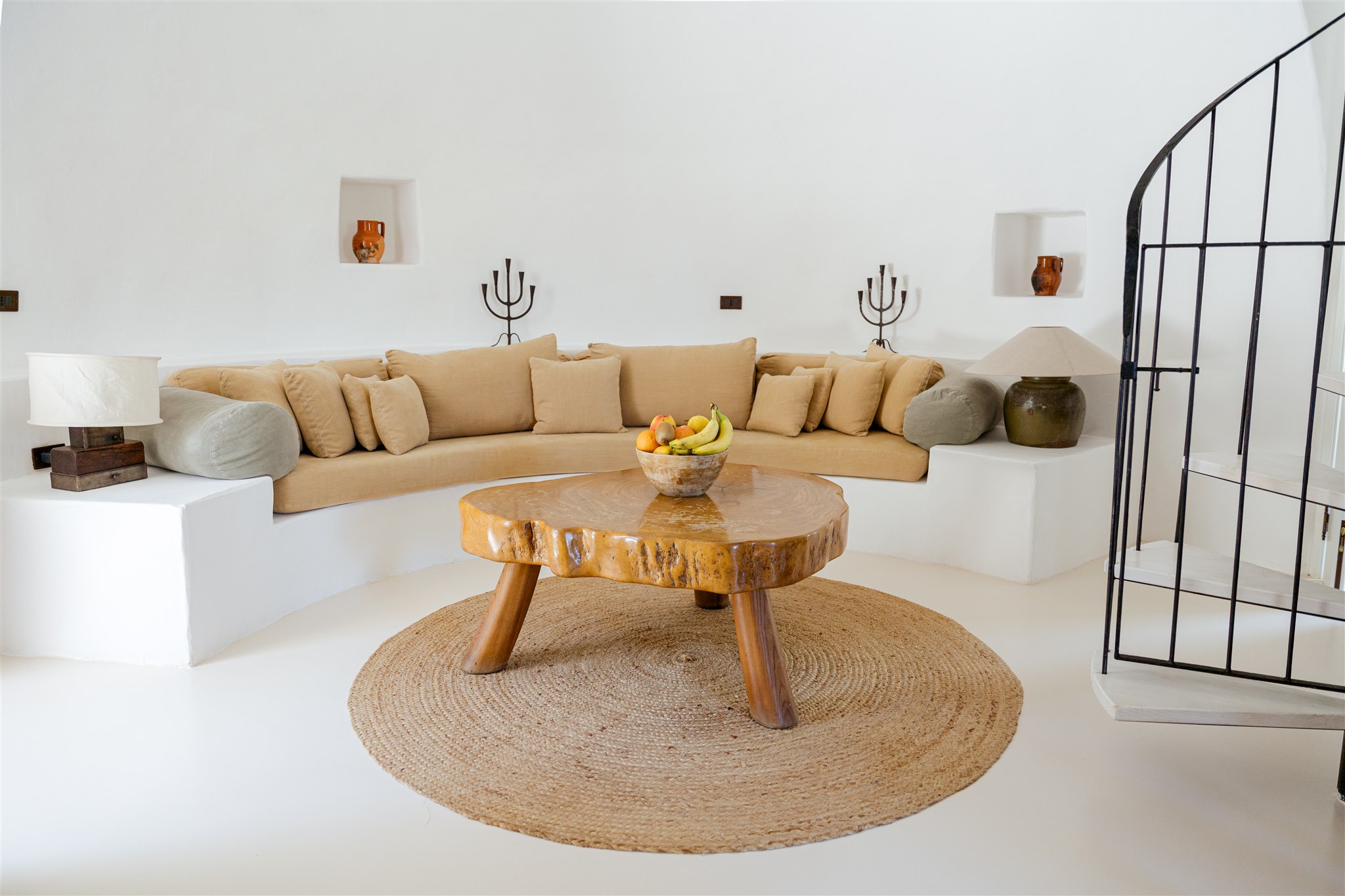 The curved sofa and spiral staircase in the Trullo sitting room