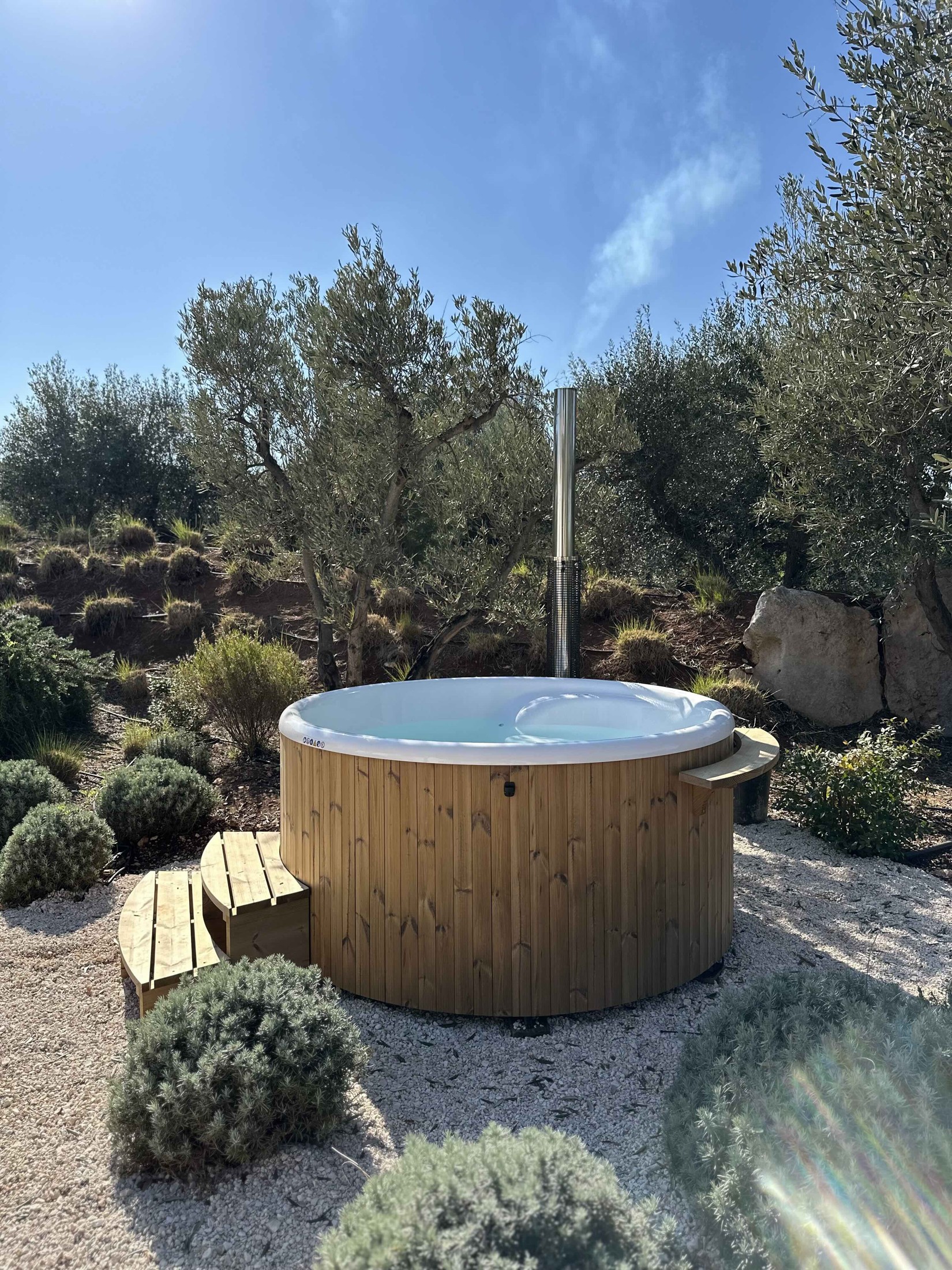 The hot tub in the sunshine in the private garden
